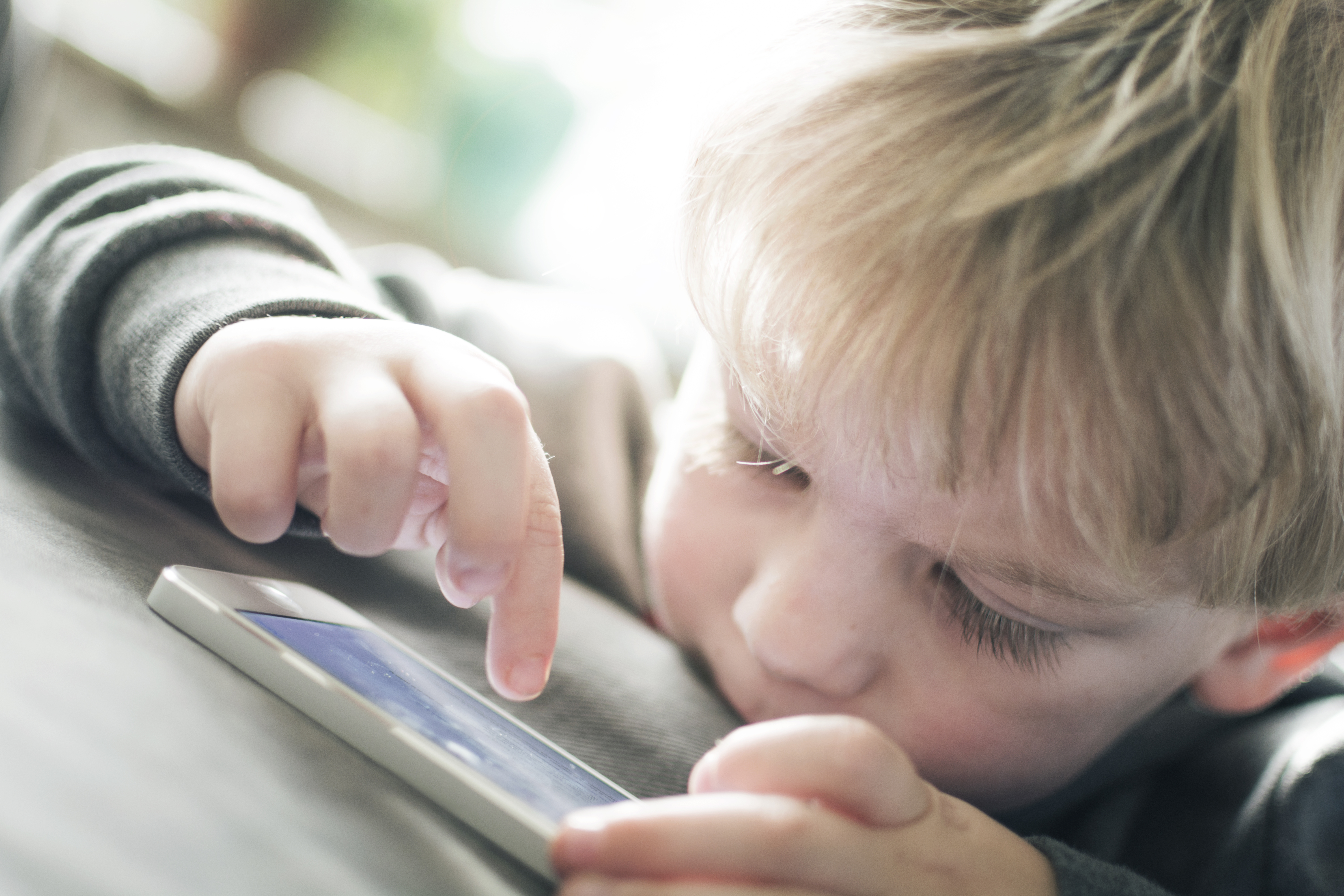Little boy playing on a smart phone